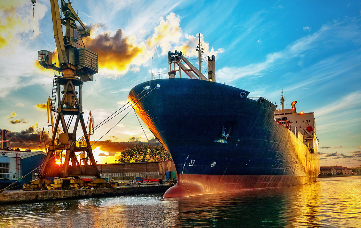 Container ship and cranes at a port at sunset